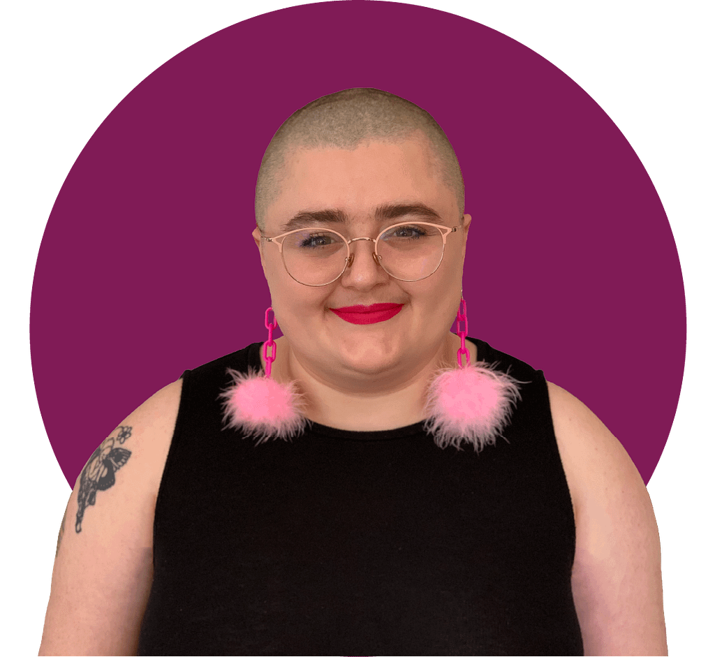Headshot of Moya, a fat white nonbinary person with a shaved head, wearing pink rimmed glasses.