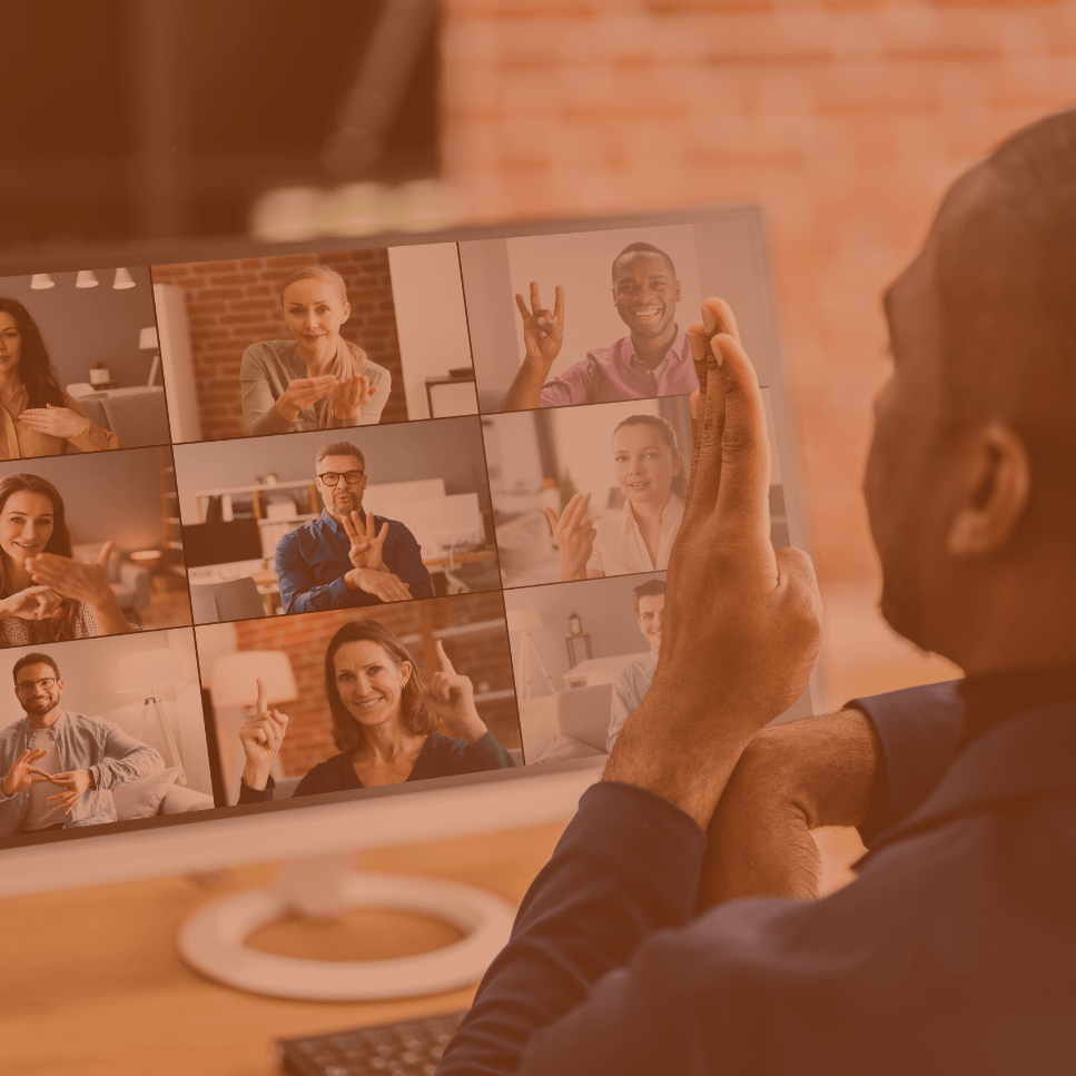A Black man speaks sign language during an online meeting while people on screen also speak sign language