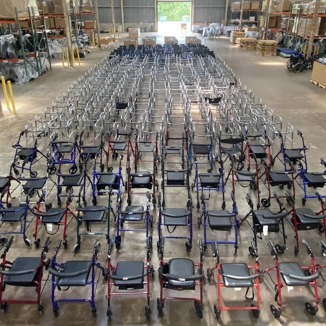 Hundreds of walkers and rollators lined up in neat rows in a large warehouse