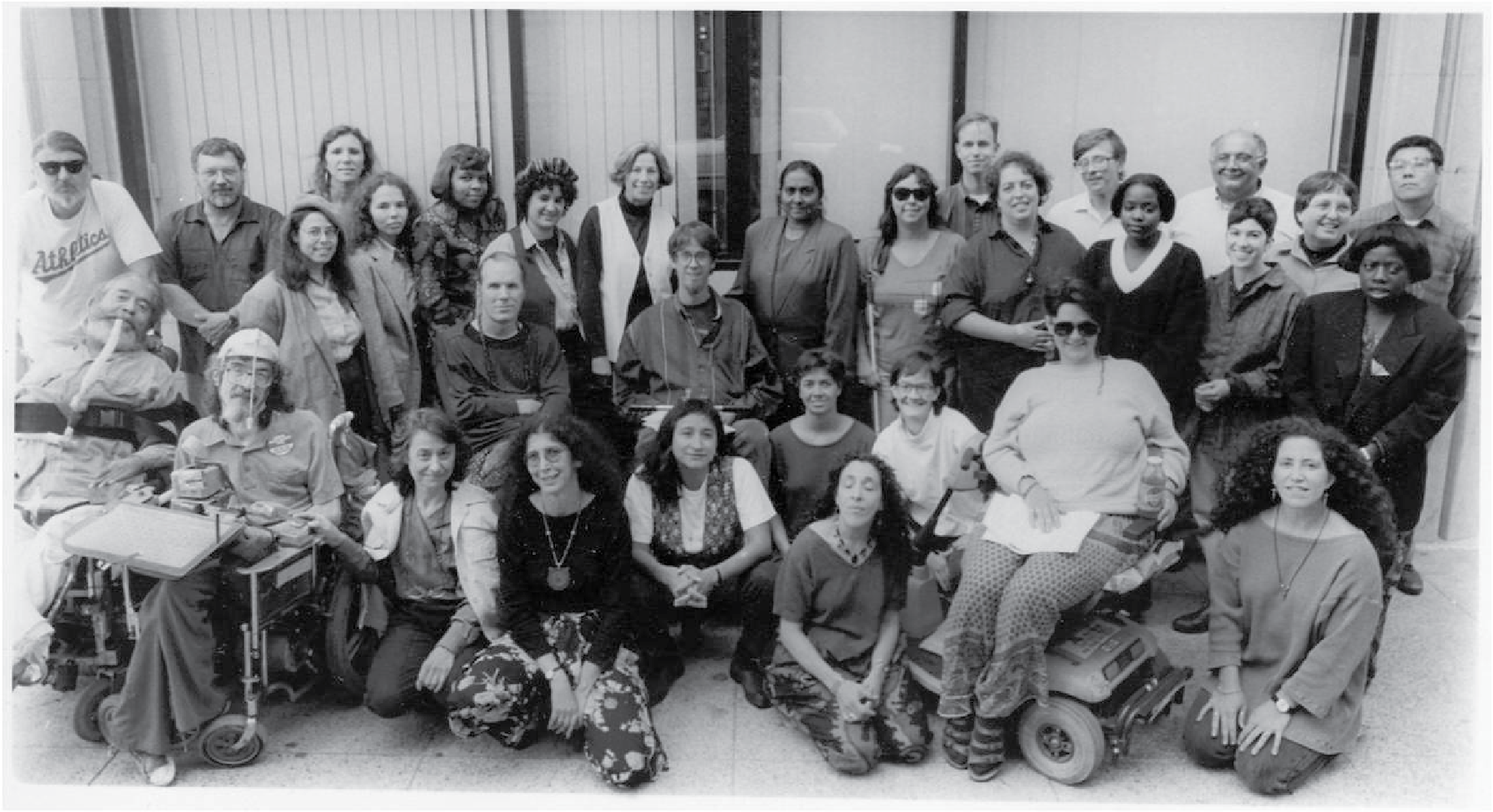 Black and white photo of WID staff of 30 people in the 80s/90s, including Ed and Joan