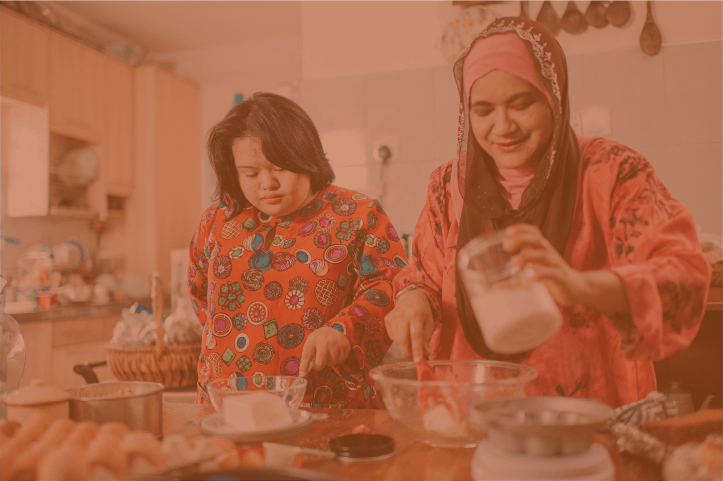 A Malaysian mother and her daughter with Down Syndrome baking in the kitchen.