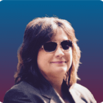 Headshot of Susan Mazrui, a white woman with shoulder length brown hair wearing dark sunglasses.