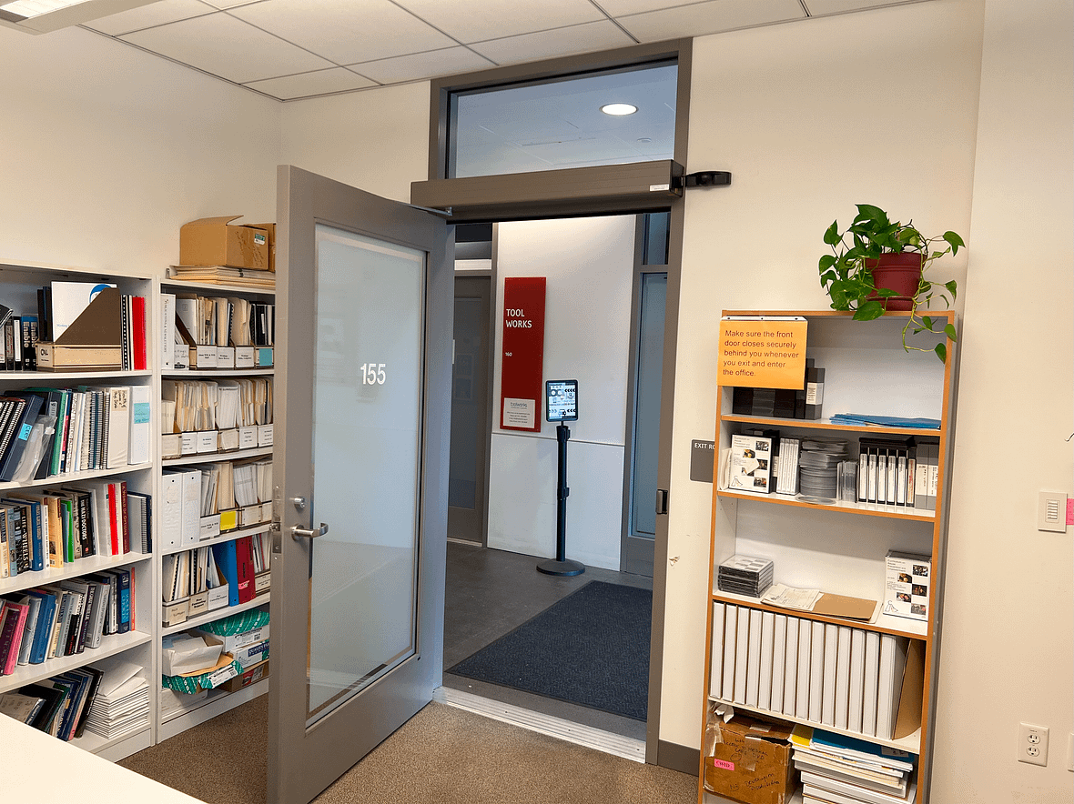 Entrance to WID office, with an automatic door that opens to several bookshelves full of resources