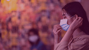 A woman adjusting her face mask.
