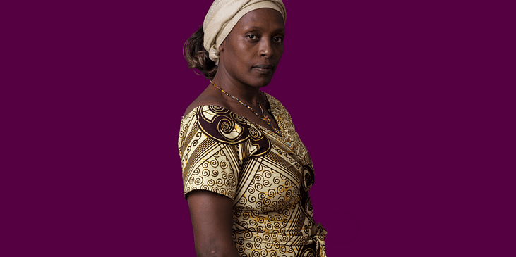 Neema Namadamu, a Black woman wearing a beige patterned traditional Congolese headwrap and dress