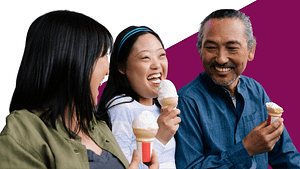 A family of 3 Asian people, two adults and one disabled child happily eating ice cream together.