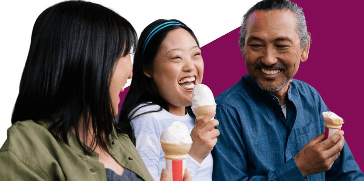 A family of 3 Asian people, two adults and one disabled child happily eating ice cream together.