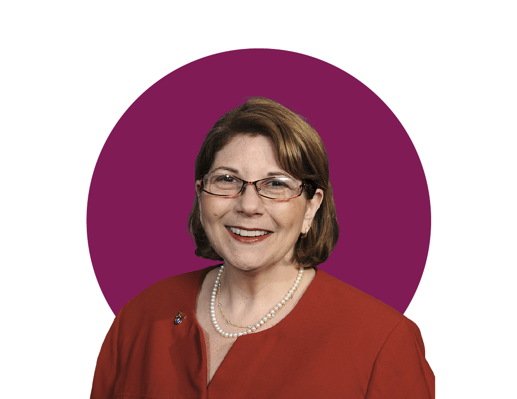 Headshot of Marcie Roth, a white woman with chin-length brown hair and red rectangular glasses.