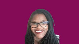 Lorrell Kilpatrick, a Black woman with locks, red lipstick and eyeglasses smiling