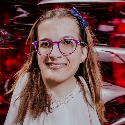 Image of article author Borbála Ivicsic, a white woman with purple glasses, medium length light brown hair and a white blouse.