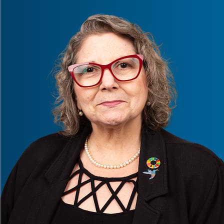 Headshot of Marcie Roth, a white woman with chin-length brown hair and red rectangular glasses.