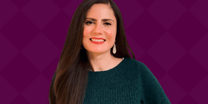 Conchita Hernandez, A light brown Latina woman with brown hair and a green sweater smiles.