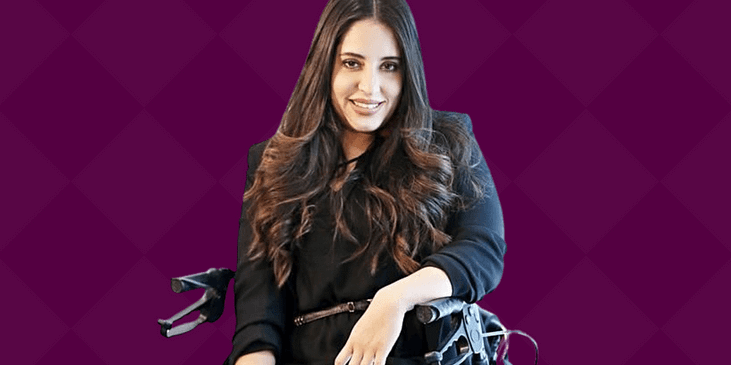 Maryangel Garcia-Ramos, a light brown Mexican woman sits in a power wheelchair and smiles.