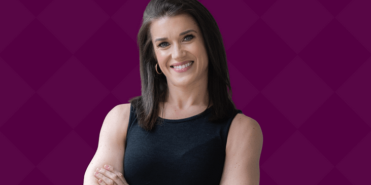 Rebecca Alexander, a white woman with shoulder-length brown hair and a black blouse stands with her arms crossed smiling.