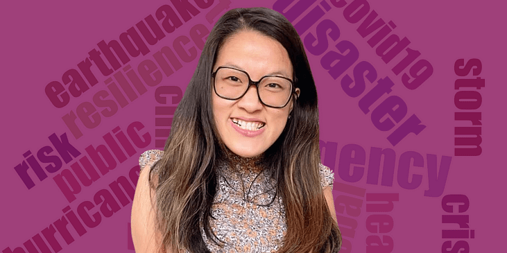 Sarah Kim, an Asian woman with long brown hair, black-rimmed eyeglasses and an animal print-patterned blouse smiles. Behind her is a world cloud of several disaster and emergency-related terms.