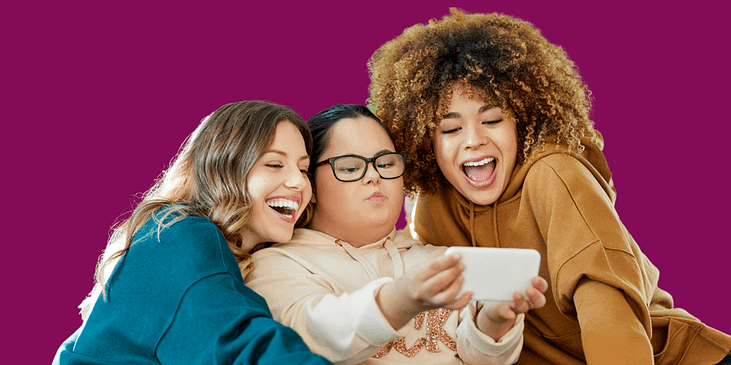 Three young women take a selfie on a smartphone.
