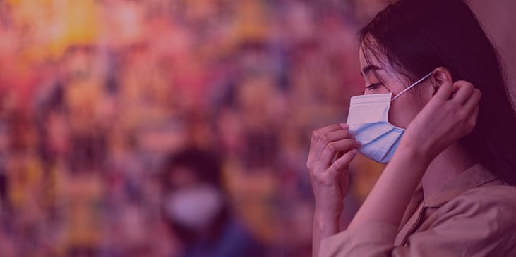 A woman adjusting her face mask.