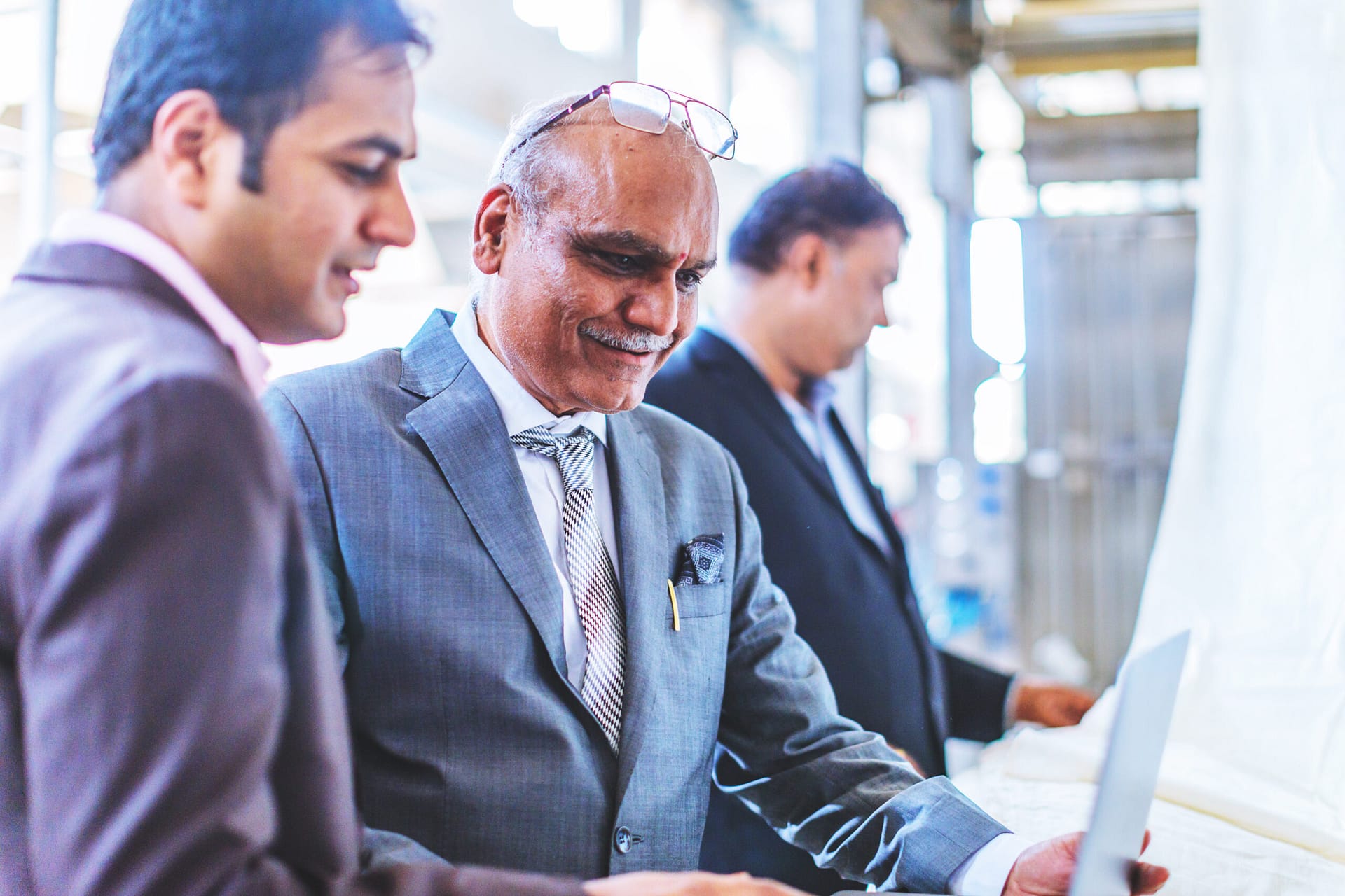 Decorative image of two Indian senior businessmen reviewing information on a computer
